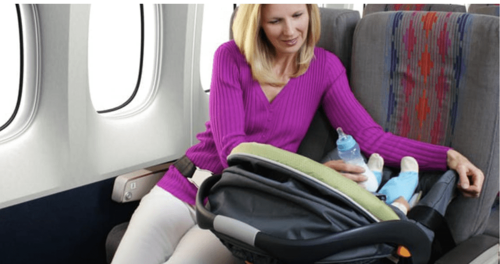 Mother on airplane with infant in rear facing car seat